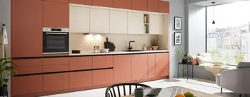 Moderne Küche mit terrakottafarbenen Fronten und hellen Holzoberschränken.